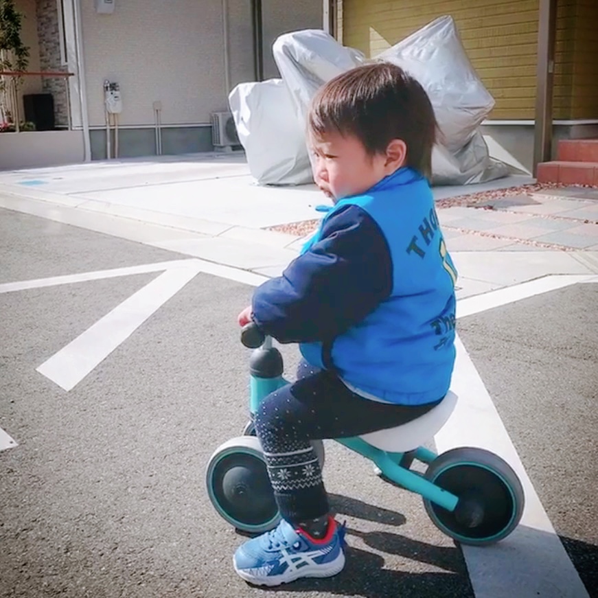 三輪車に乗って遊ぶ二歳児
